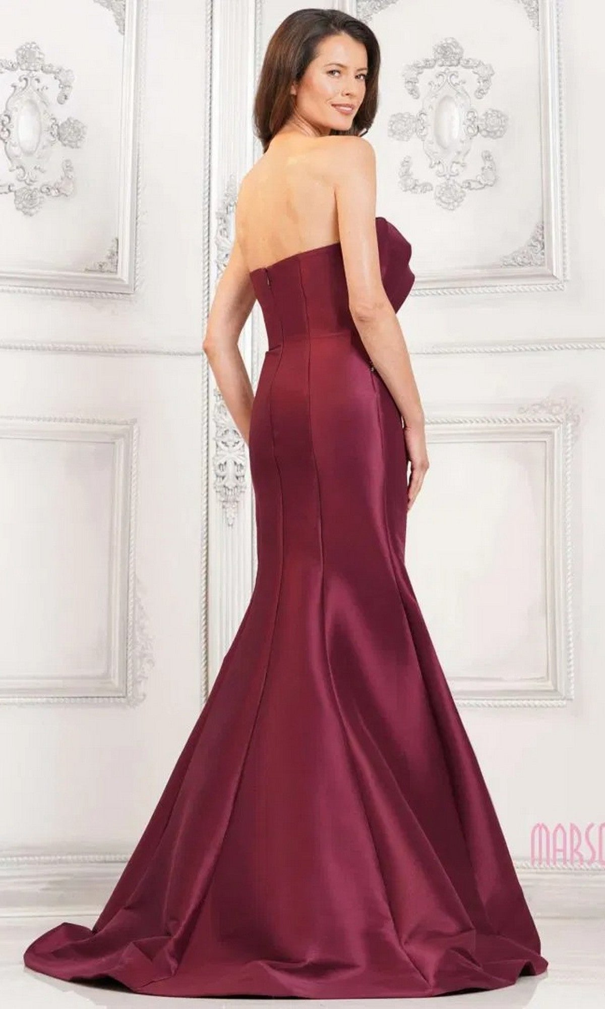 A woman in the Marsoni MV1308, a long formal red strapless mermaid gown.